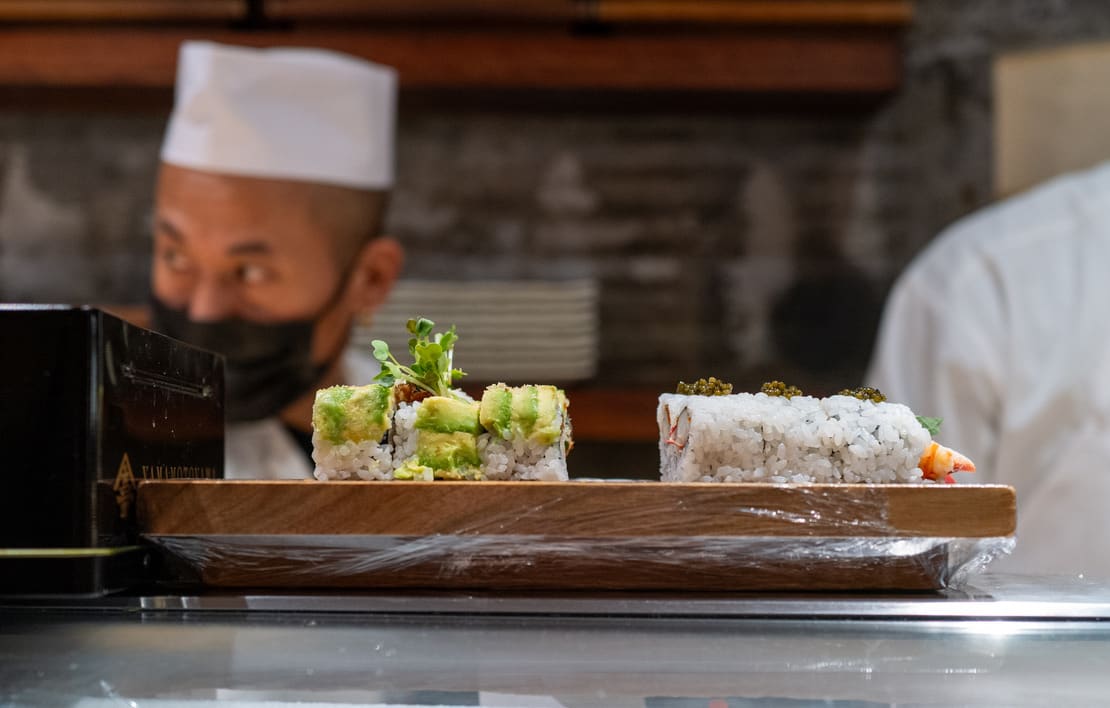 A chef prepares food behind a restaurant counter in New York